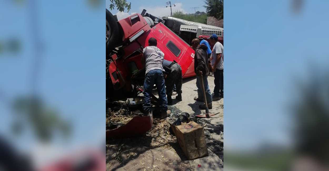 Foto: Diversas personas se acercaron al camión volcado para ayudar al conductor.