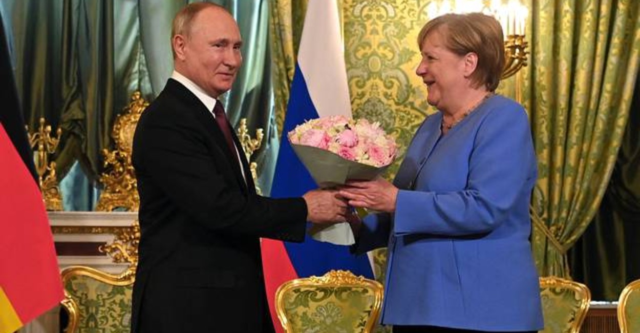 Vladimir Putin entregó un ramo de flores a Ángela Merkel. | Foto: AFP.