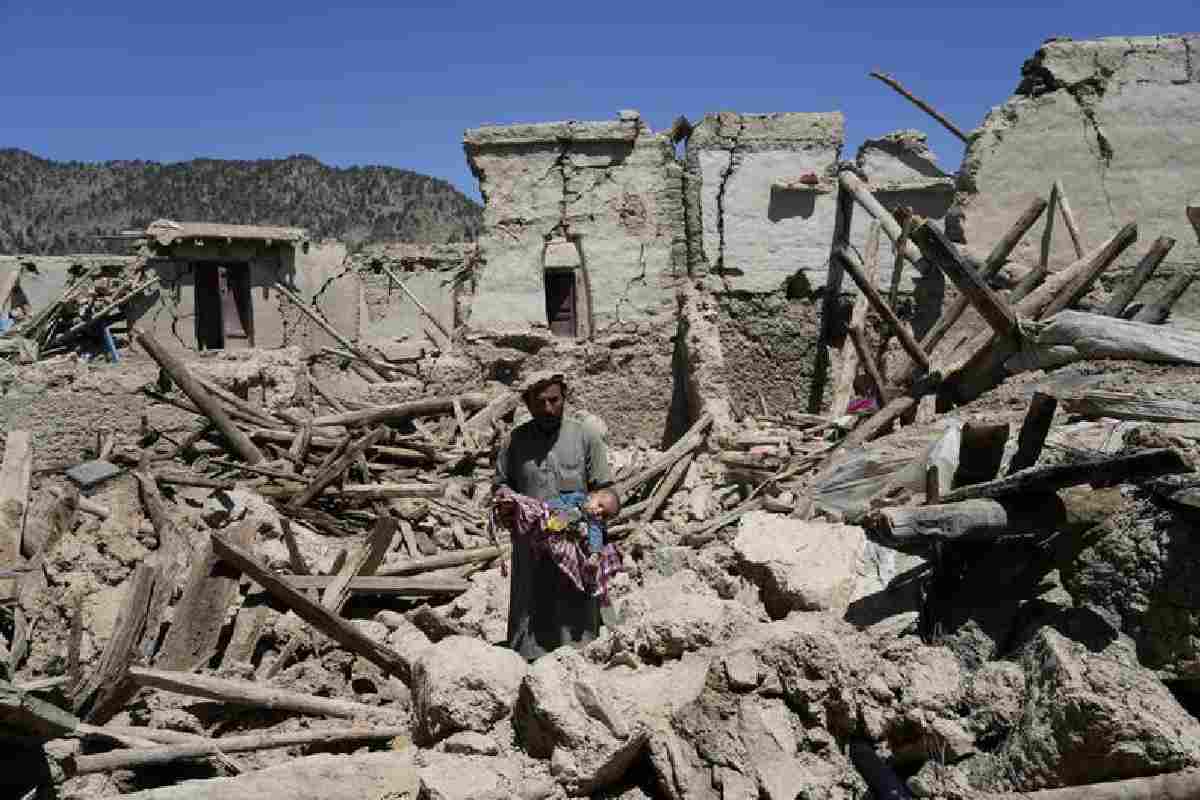 Hombre lleva a su hijo en brazos entre los escombros. Terremoto en Afganistán: suman 155 niños muertos, informa la ONU